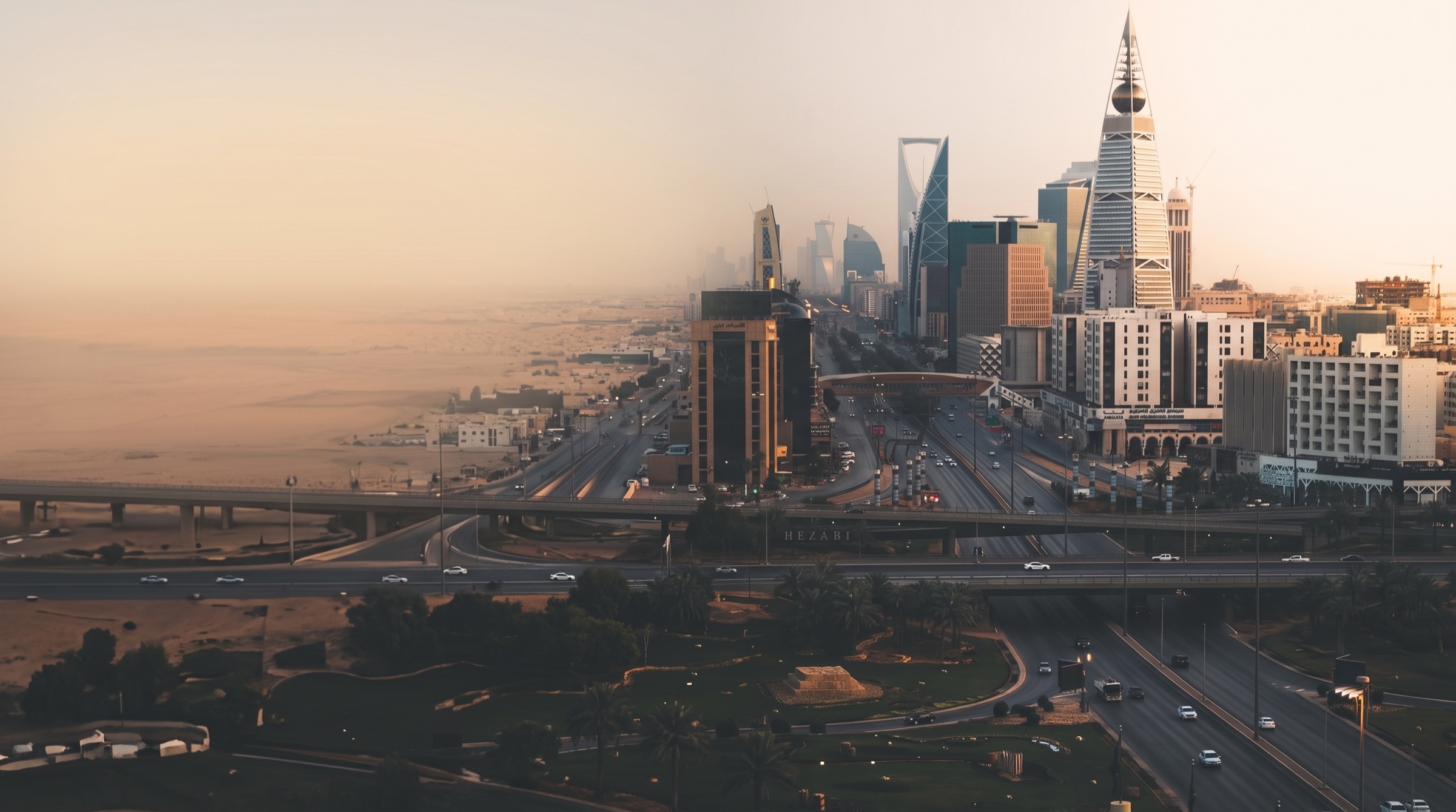 الرياض عند الغروب من الأعلى — برج الفيصلية وأبراج طريق الملك فهد فوق تقاطعات المدينة